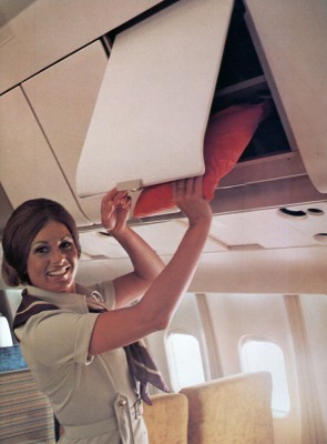 The overhead bins featured a fold-back shelf for larger items but still had limited space. (TWA)
